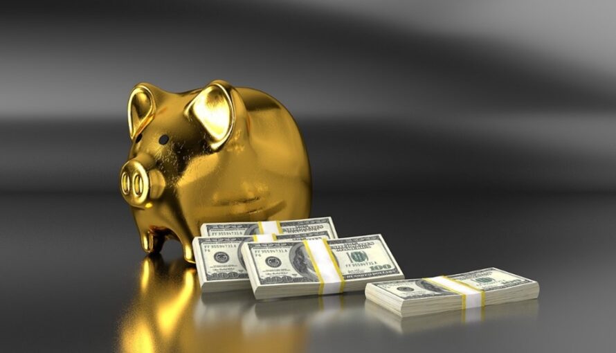 Image of money stacked next to a gold piggy bank to symbolize the money saved using a DSCR loan.