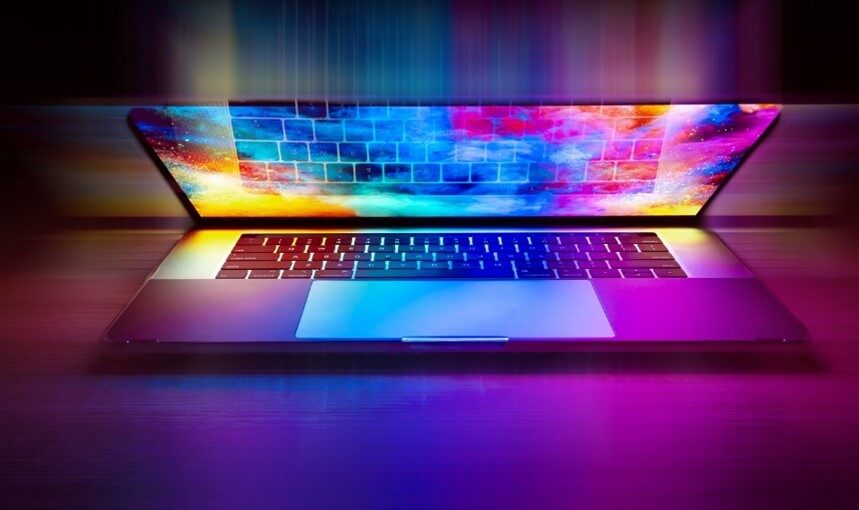 Image of a laptop with a colorful array illuminating from it.